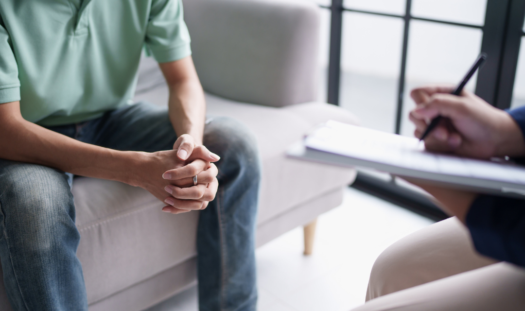 Provider talking to a patient seated on couch